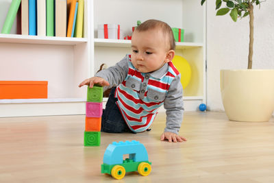 Cute boy playing with toy at home