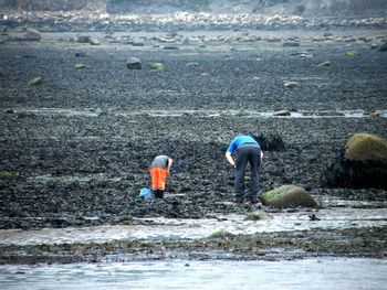 People walking on shore by river