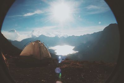 Sun shining through clouds over mountains