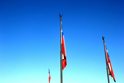 Low angle view of flags against blue sky