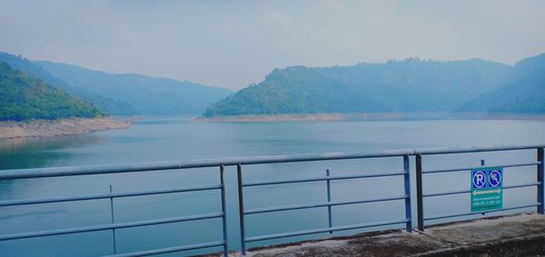 Scenic view of lake by mountains against sky