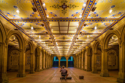 Rear view of man walking in illuminated building