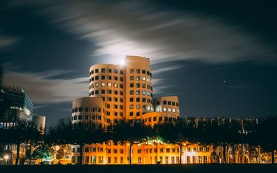 Illuminated buildings against sky at night