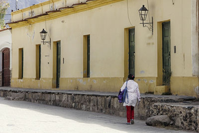 Rear view of woman walking on built structure