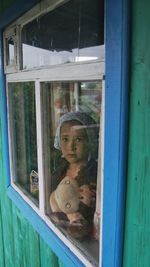 Portrait of girl seen through window