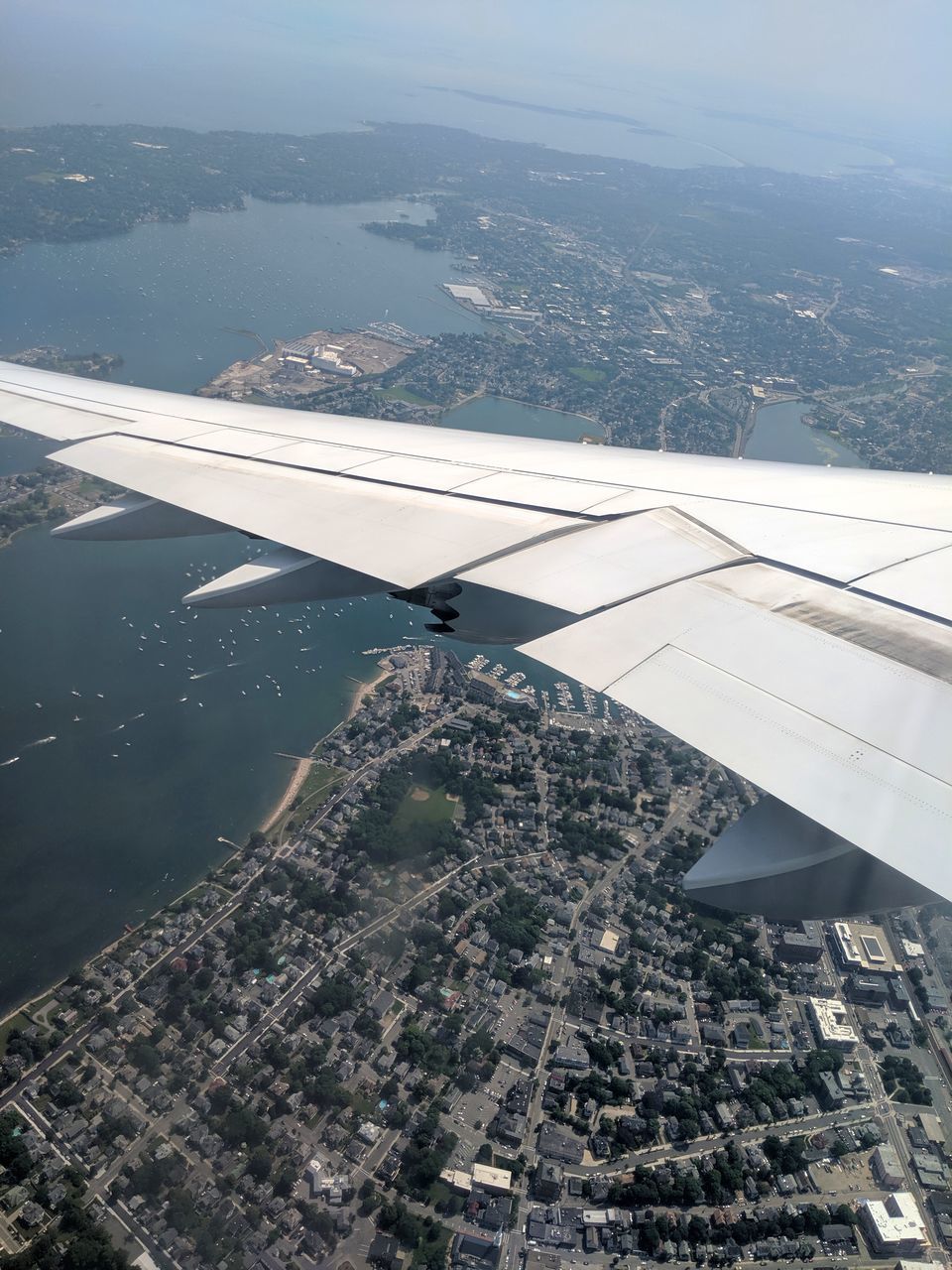 airplane, air vehicle, flying, transportation, aircraft wing, architecture, mode of transportation, aerial view, environment, nature, city, day, mid-air, building exterior, travel, built structure, no people, landscape, water, beauty in nature, outdoors, cityscape