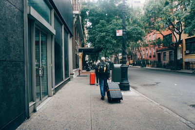 People on street amidst buildings in city