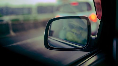 Close-up of side-view mirror seen through car window