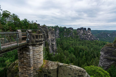 Built structure on landscape against cloudy sky