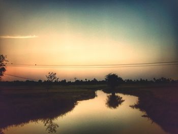 Scenic view of lake against sky at sunset