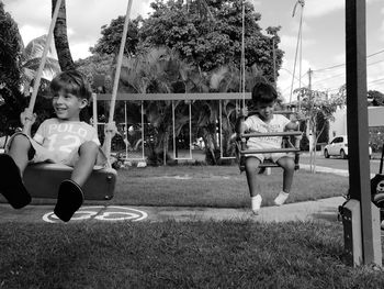 Full length of boys on swing at park