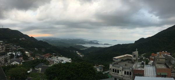 Panoramic view of townscape and mountains against sky