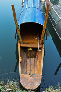 Boat moored at lakeshore against blue sky