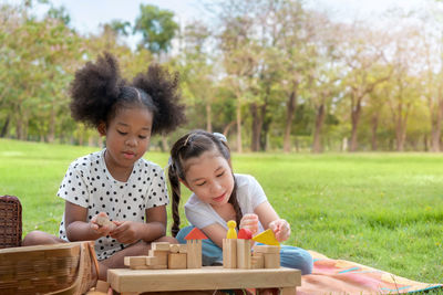 Happy girl looking at toy while sitting on plants