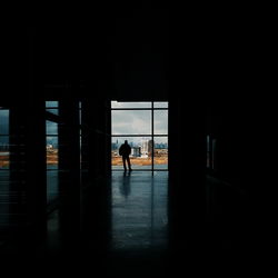 Silhouette man standing in corridor of building