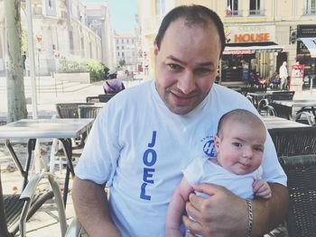 Portrait of father sitting with son at cafe