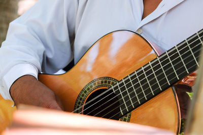 Midsection of man playing guitar