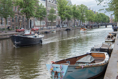 Boats moored on river in city