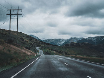 Road leading towards mountains against sky