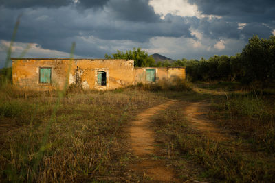 Old farmers house on field against sky in greece