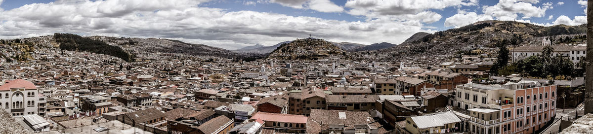 Aerial view of town by mountains against sky