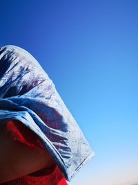 Low angle view of man against clear blue sky