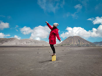 Full length of boy standing on land against sky