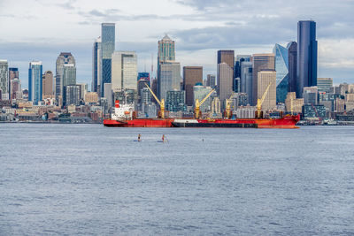 A ship is moored in front of the seattle skyline.