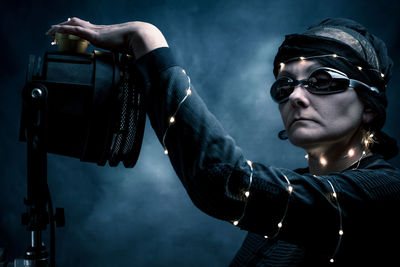 Woman wearing costume against black background