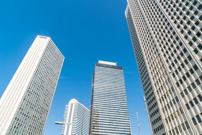 Low angle view of modern buildings against clear blue sky