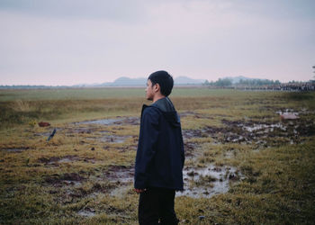 Man standing on field against sky