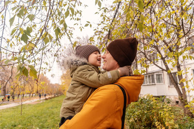 Father and son against trees during autumn