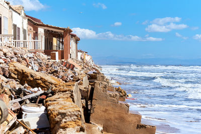 Built structure by sea against sky