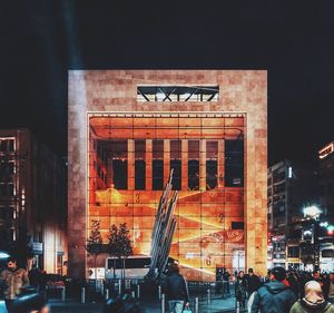 People in modern building at night