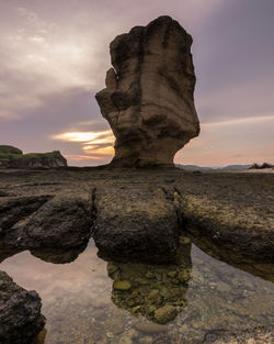 Rock formation against sky during sunset
