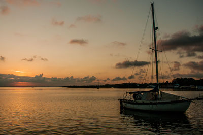 Boats sailing in sea against sky during sunset