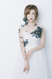 Portrait of woman standing against white background