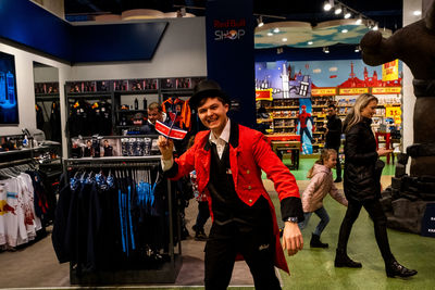 Portrait of happy friends standing against store