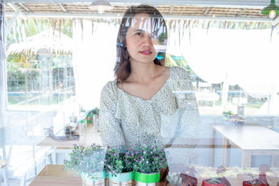 Portrait of woman seen through window