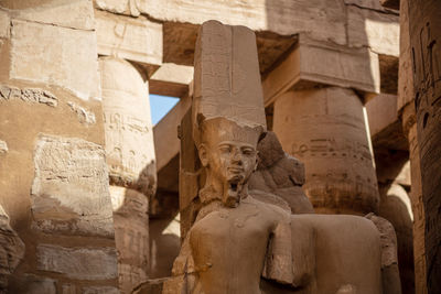 Statues of ancient egyptian pharaohs and gods. various hieroglyphs on the walls.