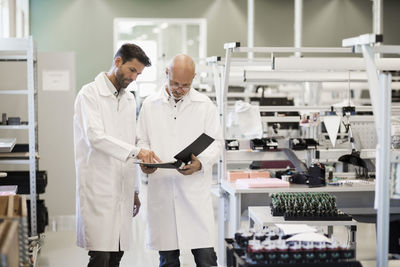 Male engineers discussing over file in industry