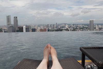 Low section of woman relaxing on sea