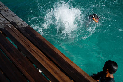 High angle view of boy and girl swimming in sea