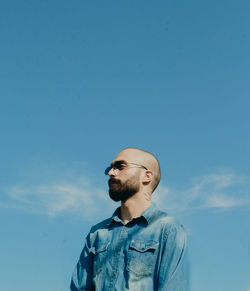 Portrait of young man against blue sky