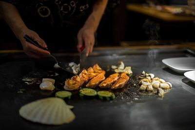 Midsection of person preparing food in kitchen