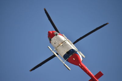 Low angle view of airplane against clear blue sky