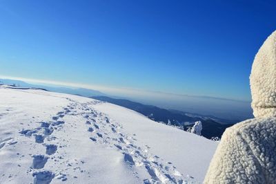 Scenic view of snow covered landscape against clear blue sky