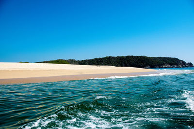 Scenic view of sea against clear blue sky