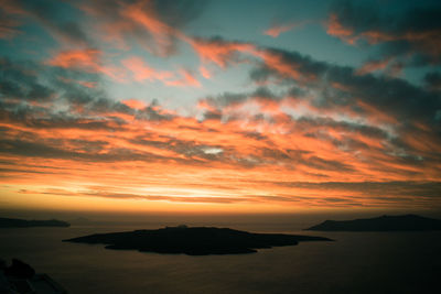 Scenic view of sea against dramatic sky during sunset