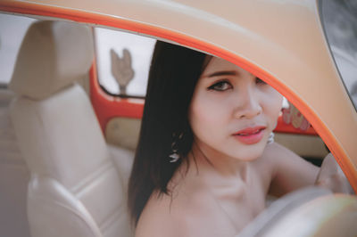 Close-up portrait of young woman in car